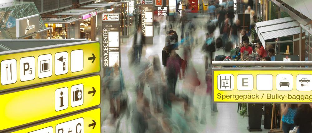 Passagiere laufen durch den Flughafen Tegel. 