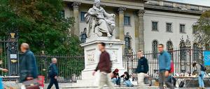 Vor der Humboldt-Universität gehen Passanten über den Bürgersteig.