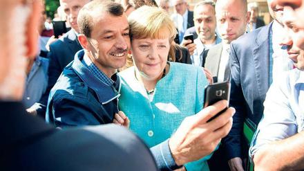 Angela Merkel und ein Flüchtling beim „größten Sozialexperiment Europas seit der Russischen Revolution“ (Sarrazin).