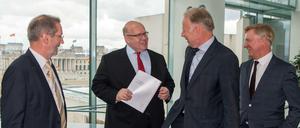 Die drei Kommissions-Vorsitzenden Ole von Beust (r, CDU), Matthias Platzeck (l, SPD) und Jürgen Trittin (2vr, Bündnis90/Die Grünen) übergeben im Bundeskanzleramt in Berlin den Bericht mit den Empfehlungen der "Kommission zur Überprüfung der Finanzierung des Kernenergieausstiegs" (KFK) an Kanzleramtsminister Peter Altmaier (CDU). 