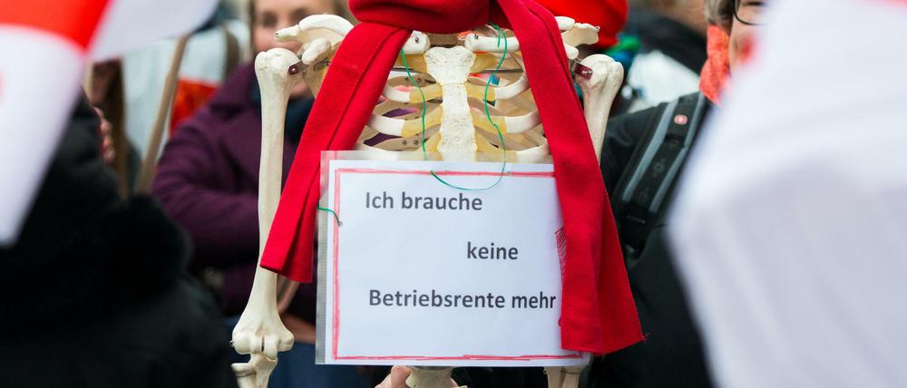 Ein Skelett mit einem Schild "Ich brauche keine Betriebsrente mehr" während eines Warnstreiks.