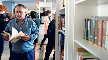 Neue Heimat für Bücher und Menschen. Ein Syrer blättert in der Begegnungsstätte des ehemaligen Flughafens Tempelhof in einem arabischen Buch.