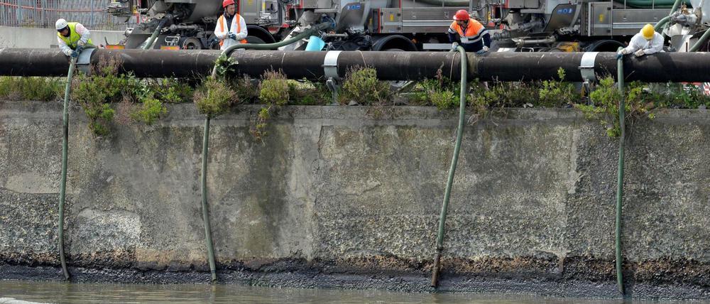 Einsatzkräfte versuchen, Öl aus dem Fluss Polcevera abzupumpen.