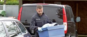 Ein Ermittler trägt am 6. Mai 2015 in Augsburg Beweismittel aus der Wohnung eines Verdächtigen.