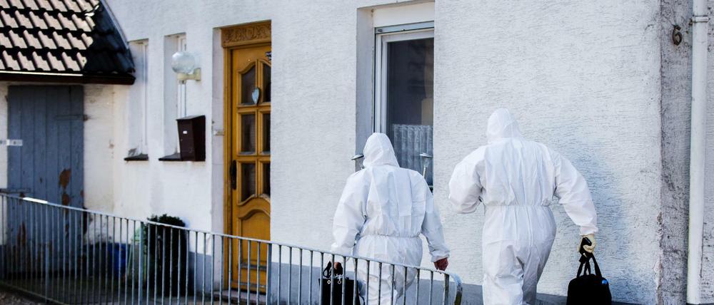 Mitarbeiter der Spurensicherung in Höxter am Haus des beschuldigten Ehepaares vorbei.