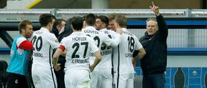Freiburgs Spieler und Trainer Christian Streich (r) feiern das 1:0 gegen Paderborn.