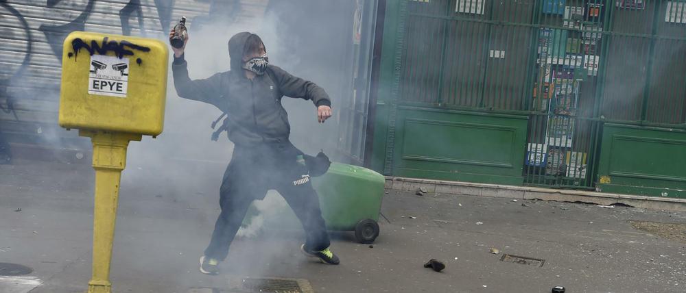 Ein Demonstrant schleudert in Paris bei den Protesten gegen die Arbeitsmarktreform eine Flasche auf Polizisten.