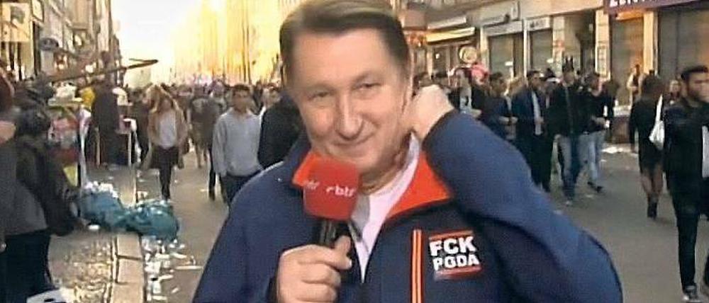 Auf Sendung. RBB-Reporter Ulli Zelle mit dem Anti-Pegida-Aufkleber.