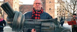 Der schwedische Künstler Carl Fredrik Reuterswärd posiert 1996 hinter seiner Bronzeplastik am Sendlinger Tor in München.