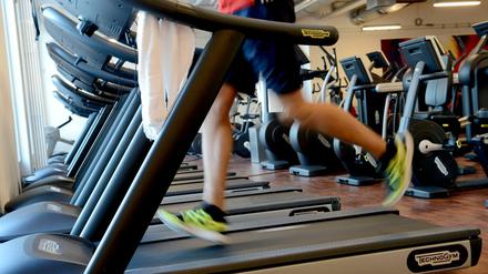 Ein Mann trainiert in einem Fitnessstudio in Berlin auf dem Laufband für seine Ausdauer.