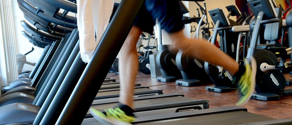 Ein Mann trainiert in einem Fitnessstudio in Berlin auf dem Laufband für seine Ausdauer.