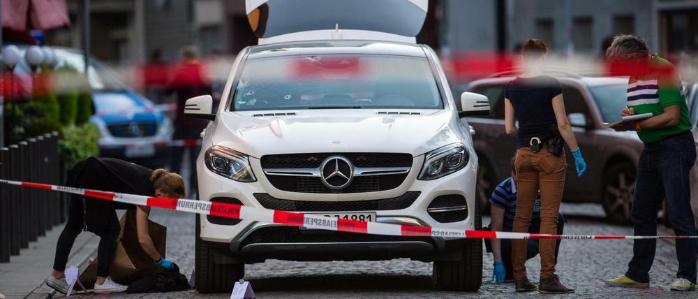 Mitarbeiter der Spurensicherung untersuchen den Tatort am weißen Mercedes-Geländewagen in Frankfurt am Main. 