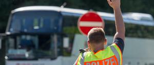 Ein Bundespolizist hält an einer Kontrollstelle an der Autobahn A 3 in Bayern einen Bus an. 
