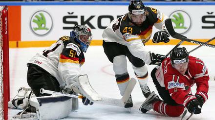Die deutsche Mannschaft wehrt sich gegen Favorit Kanada nach Kräften. Hier wird Brendan Gallagher (r.) von Gerrit Fauser gestört. Torwart Timo Pielmeier verfolgt es gespannt.