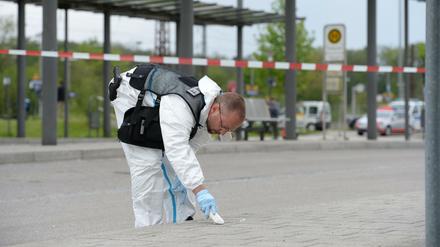 Spurensuche: Ein Ermittler der Polizei macht am Bahnhof in Grafing auf dem Boden eine Markierung. 