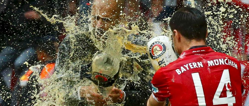 Bier um Bier. Bayerns Xabi Alonso und Trainer Pep Guardiola (links) duschen sich ab.