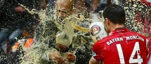 Bier um Bier. Bayerns Xabi Alonso und Trainer Pep Guardiola (links) duschen sich ab.