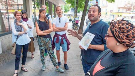 Zur Orientierung. Die Stadtführer Samer Serawan (2. v. r.) und seine Frau Arij (r.) zeigen auf Karten, wie sie nach Deutschland kamen. 