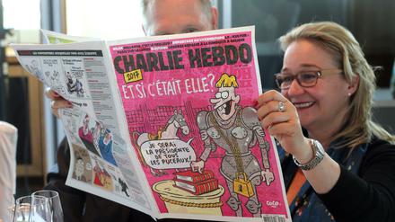 Gäste blättern in einer Ausgabe con "Charlie Hebdo".