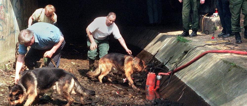 Polizeibeamte suchen am 31. März 1998 mit Hunden im Liederbach in Frankfurt-Höchst nach Spuren des ermordeten 13-jährigen Tristan.