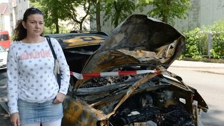 Maigonata Pytel (44) aus Polen steht an der Keplerstraße in Oberschöneweide an ihrem ausgebrannten Pkw. 