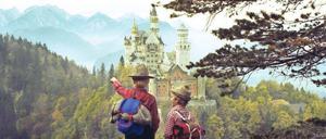 Junge Bergwanderer vor Schloss Neuschwanstein bei Füssen.