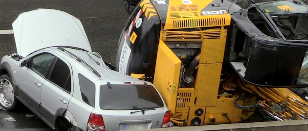 Ein Bagger liegt am Montag auf der Autobahn 40 bei Bochum auf einem PKW. Bei dem spektakulären Unfall ist ein Autofahrer bei Bochum nur knapp mit dem Leben davon gekommen.