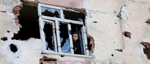 Ein Mann blickt aus einem Gebäude in Diyarbakir, das bei Kämpfen zwischen türkischen Sicherheitskräften und militanten Kurden stark beschädigt worden ist. 