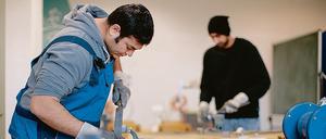 Der afghanische Flüchtling Sha Kah Ahmadi (l.) und der indischen Flüchtling Singh Satwinder feilen in der Fortbildungsakademie der Wirtschaft (FAW) in Dresden (Sachen) an Metallwerkstücken. 