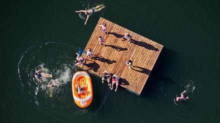 Kinder toben auf einer Holzinsel und in einem Schlauchboot in einem See bei Sarstedt im Landkreis Hildesheim. Die Badegewässer in Deutschland sind nach einer veröffentlichten Übersicht der Europäischen Union überwiegend in einem sehr guten Zustand.