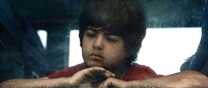 Eine Junge sitzt in einem Bus, der die Bewohner des Flüchtlingscamps in Idomeni in griechische Aufnahmezentren bringen soll.