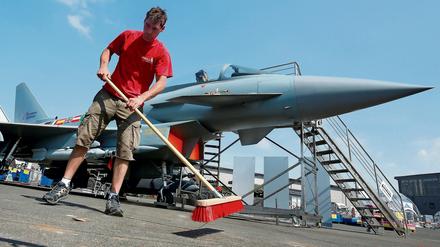 Ein Mann fegt auf der Internationalen Luft- und Raumfahrtausstellung in Schönefeld, vor einem Eurofighter das Ausstellungsgelände. 