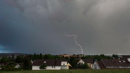 Dunkle Gewitterwolken und ein Blitz während der Abenddämmerung.