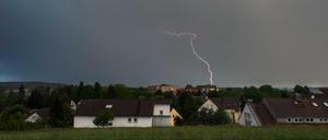 Dunkle Gewitterwolken und ein Blitz während der Abenddämmerung.