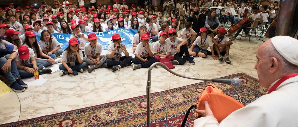 Papst Franziskus hält die Rettungsweste eines Flüchtlings in der Hand. Er traf sich mit Waisenkindern, deren Eltern ertrunken sind.