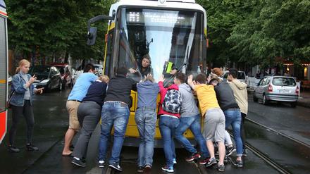 Touristen schieben die Tram zurück, damit sie wieder Strom bekommt.