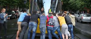Touristen schieben die Tram zurück, damit sie wieder Strom bekommt.