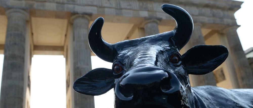 Aktivisten des Bundesverbands Deutscher Milchviehhalter demonstrieren mit einer Kuhfigur vor dem Brandenburger Tor für fairere Milchpreise.