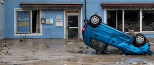 Ein Auto liegt am Donnerstag auf dem Dach in den Straßen in Simbach am Inn (Bayern).
