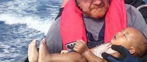 Ein deutscher Retter der Organisation Sea-Watch hält ein ertrunkenes Flüchtlingsbaby in den Armen.