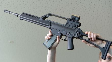 Ein Mann hält am 07.05.2015 in Oberndorf (Baden-Württemberg) in der Firmenzentrale ein Sturmgewehr G36 von Heckler &amp; Koch in die Höhe.
