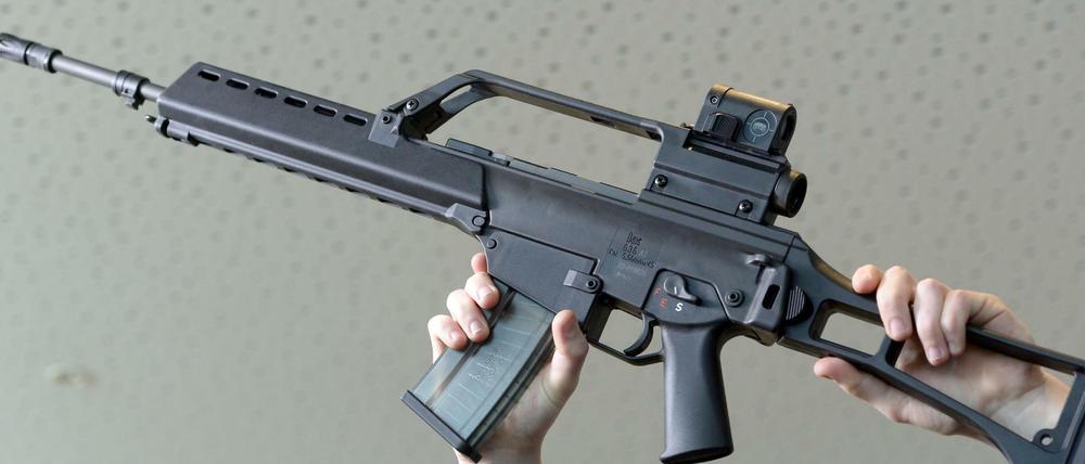 Ein Mann hält am 07.05.2015 in Oberndorf (Baden-Württemberg) in der Firmenzentrale ein Sturmgewehr G36 von Heckler & Koch in die Höhe.