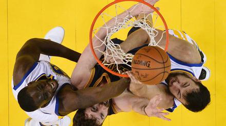 Kevin Love von den Cleveland Cavaliers ist umringt von Draymond Green (li.) and Andrew Bogut (re.) von den Golden State Warriors. 