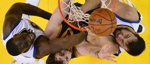 Kevin Love von den Cleveland Cavaliers ist umringt von Draymond Green (li.) and Andrew Bogut (re.) von den Golden State Warriors. 