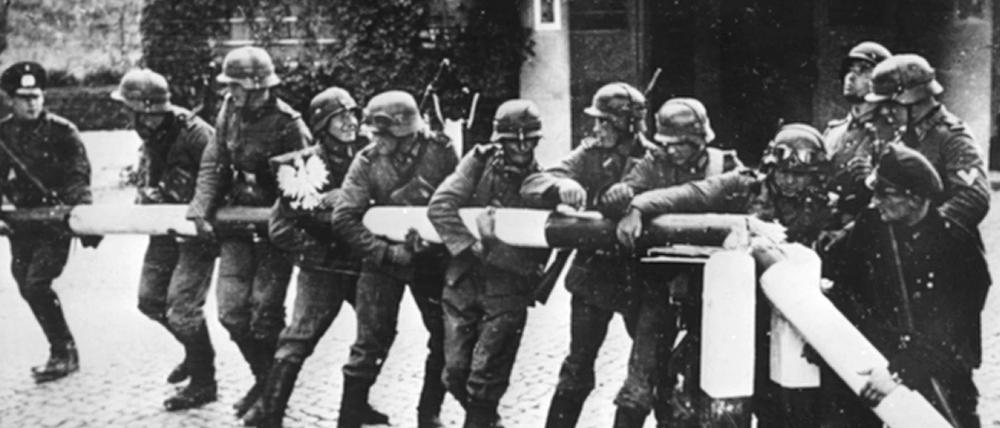 Beim Einmarsch deutscher Truppen in Polen am 1. September 1939 reißen Soldaten der deutschen Wehrmacht einen rot-weißen Schlagbaum an der deutsch-polnischen Grenze nieder. 