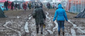 "Rock am Ring": Festivalbesucher gehen nach einem Gewitterregen über das aufgeweichte Gelände.