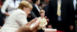 Weiches Geschenk: Ein chinesischer Künstler formt die Bundeskanzlerin bei ihrem Besuch in Shenyang aus Knete.
