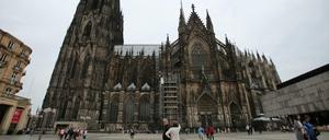 Touristen stehen vor dem Dom in Köln