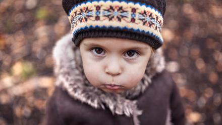 Portrait of pouting little girl in autumn.