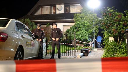 Polizisten stehen in der Nacht zum Donnerstag vor einem Haus in Hamburg-Schnelsen, in dem zuvor Schüsse gefallen sein sollen. Bei einer Schießerei im Rockermilieu sind nach ersten Angaben drei Menschen verletzt worden.